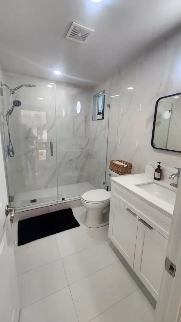White marble bathroom with a glass shower after a deep clean