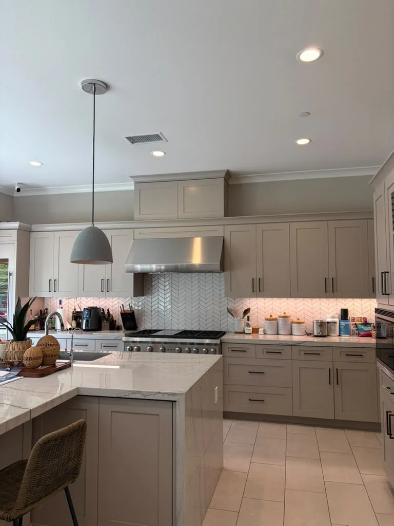 Kitchen with stainless range hood and herringbone backsplash after a deep clean