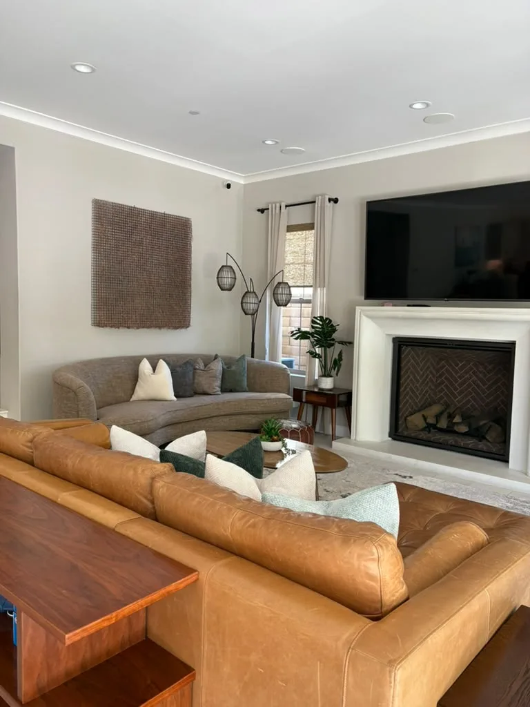 Living room with a leather sectional and fireplace after a cleaning
