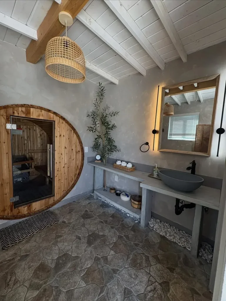 Spa-style bathroom with a round wood door and stone floor after cleaning