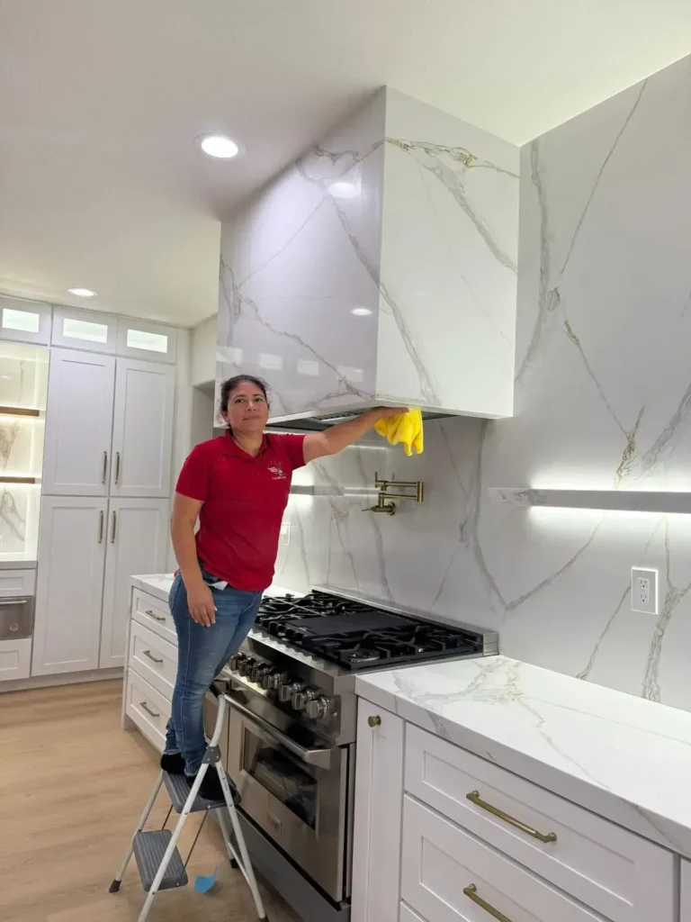 Orozco's team member cleaning a kitchen range hood