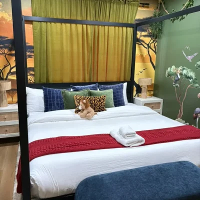 Themed Airbnb bedroom with fresh linens and folded towels