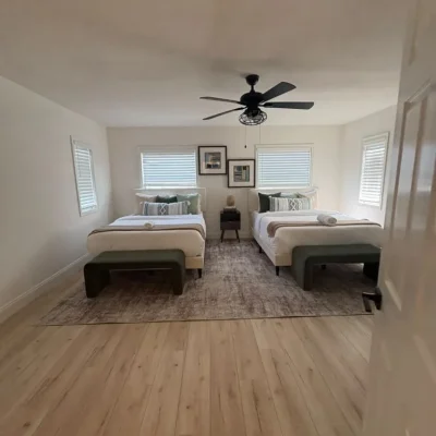 Empty guest bedroom with two beds after a move out cleaning